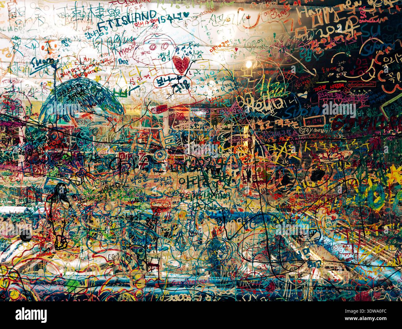 Intérieur de brasserie coloré couvert de graffitis à Incheon, Corée du Sud, avec des messages manuscrits et des dessins couvrant la fenêtre. Banque D'Images
