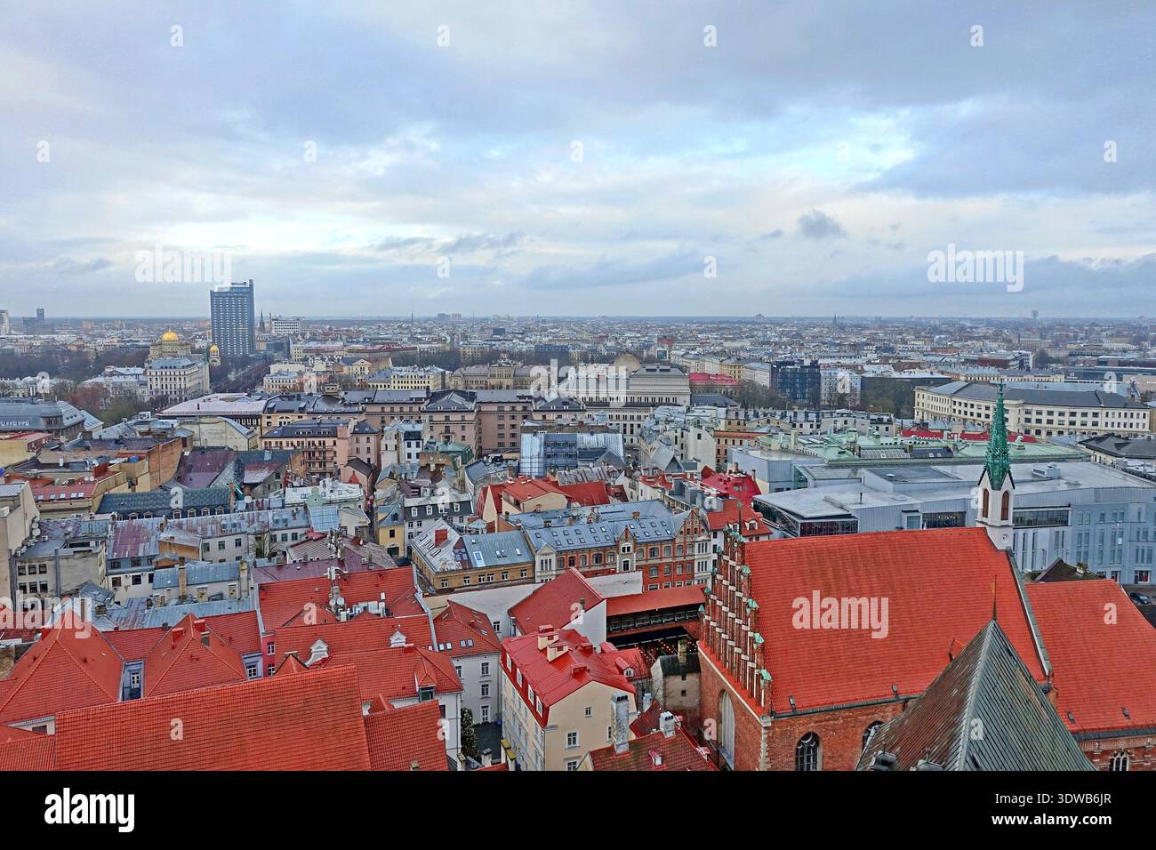 Vue panoramique sur les toits de la vieille ville et les bâtiments modernes au loin lors d'une journée couverte à Riga, Lettonie Banque D'Images