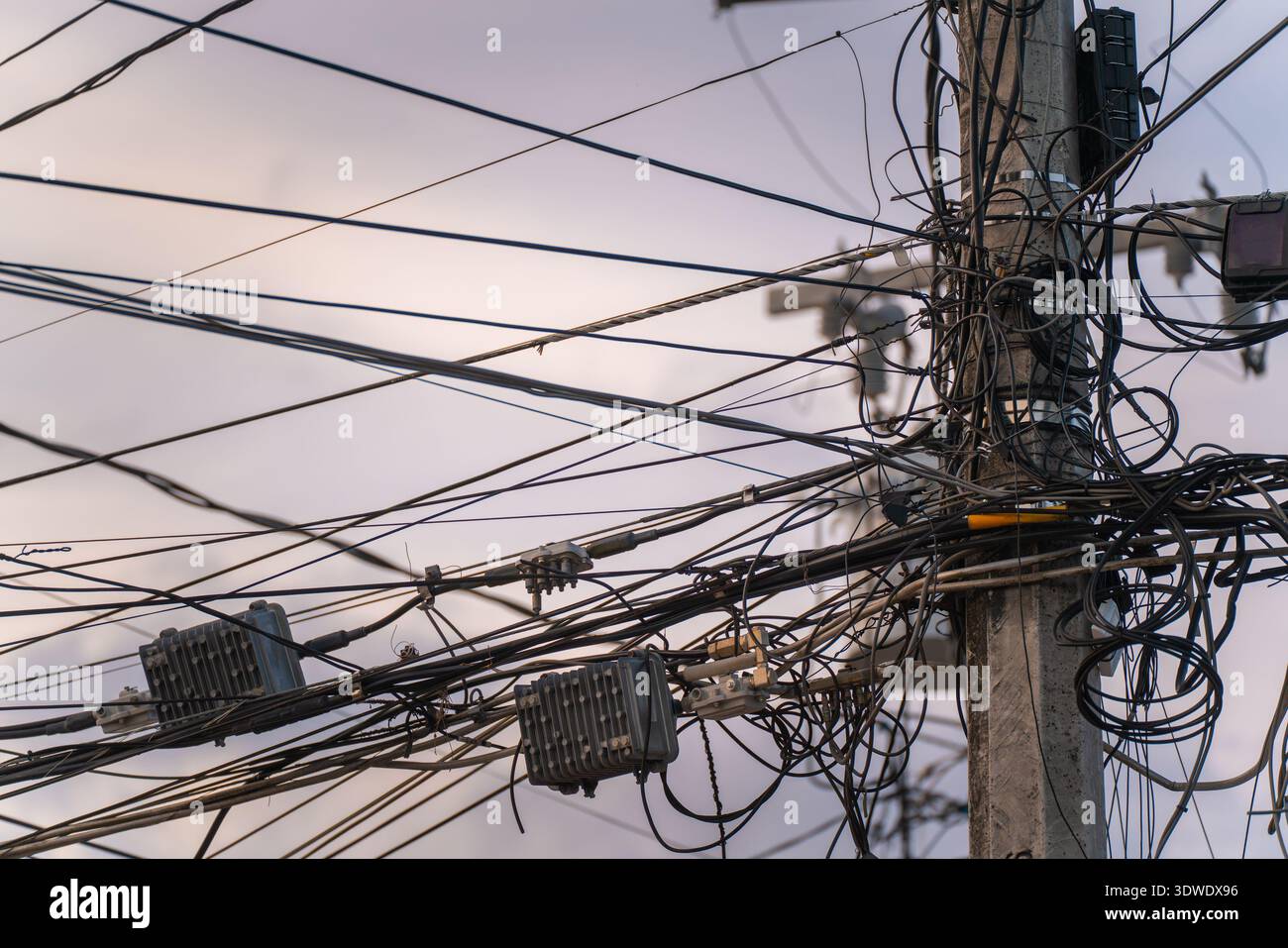 Une vue rapprochée de fils électriques enchevêtrés sur un poteau de service, mettant en évidence la complexité et l'organisation de l'infrastructure urbaine moderne contre un CLO Banque D'Images