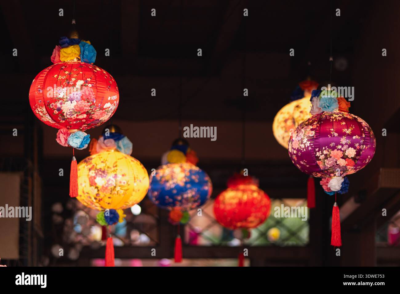 Des lanternes vibrantes ornées de motifs floraux illuminent la scène, créant une atmosphère festive. Ces ornements décoratifs sont parfaits pour célébrer Banque D'Images