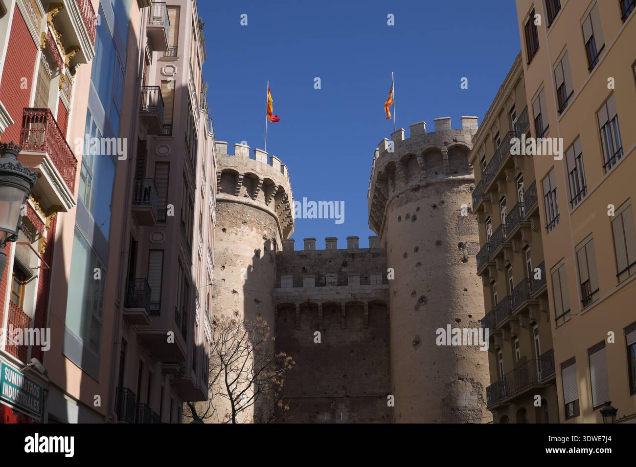 Torres de quart. Tours de portes gothiques du XVe siècle à Valence, en Espagne, encadrées par des immeubles d'appartements contemporains sous un bleu lumineux Banque D'Images