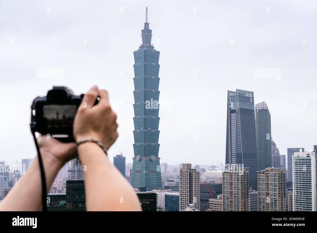 Un photographe capture l'emblématique Taipei 101 au milieu de l'horizon moderne par une journée nuageuse à Taipei, Taiwan. Cette image met en valeur le mélange de l'Ar urbain Banque D'Images