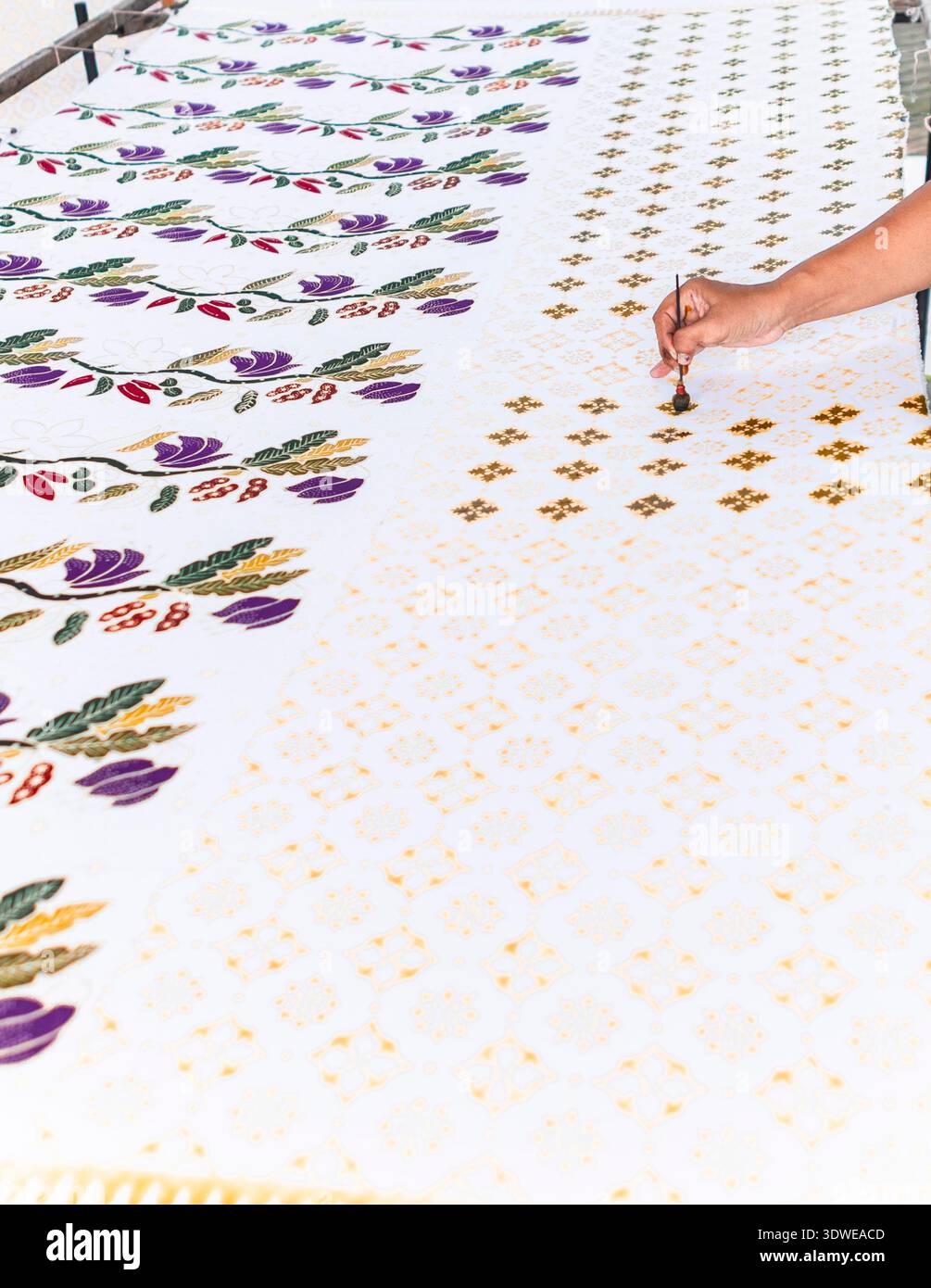 Un artisan habile peint un tissu batik indonésien traditionnel, mettant en valeur des motifs complexes. Le batik est reconnu par l’UNESCO comme un H culturel immatériel Banque D'Images