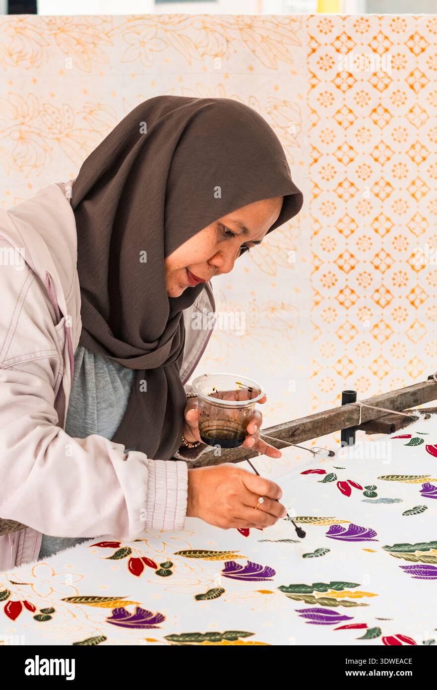 Un artiste habile à la main un design batik indonésien complexe. Reconnue par l’UNESCO comme patrimoine culturel immatériel, cette forme d’art incarne Banque D'Images