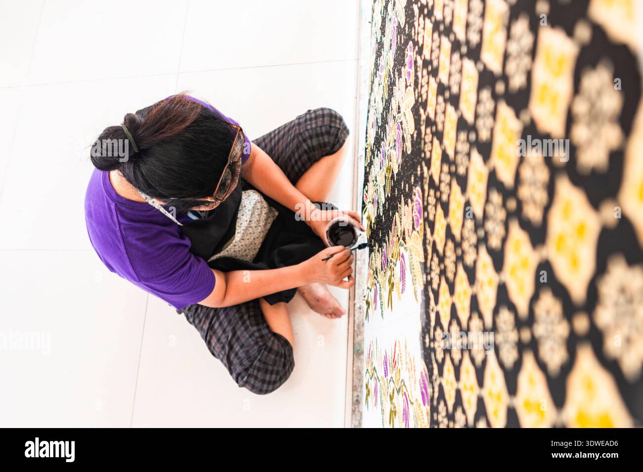 Un artiste qualifié peint à la main un tissu batik traditionnel indonésien, patrimoine culturel immatériel de l'humanité reconnu par l'UNESCO. Le motif complexe Banque D'Images
