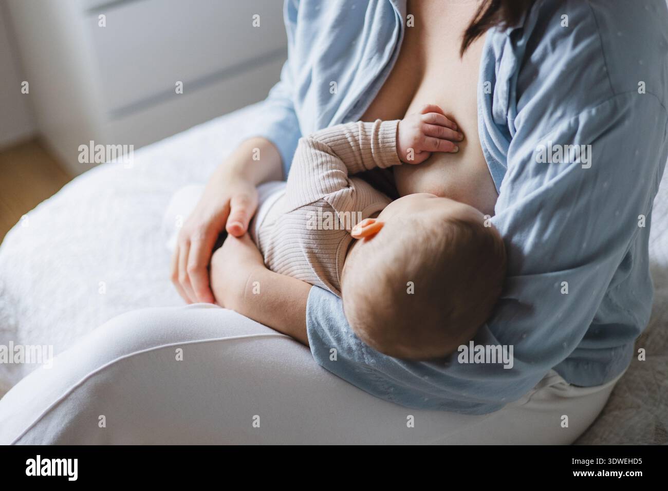 Une mère allaite avec amour son nouveau-né dans un environnement serein, mettant en valeur la chaleur et le lien de la maternité précoce et le pro des soins doux Banque D'Images