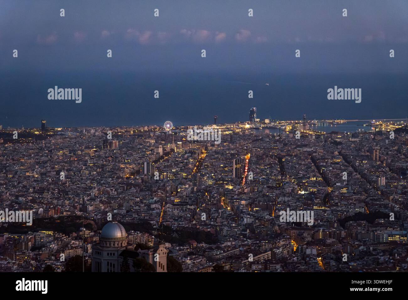 Une vue imprenable sur Barcelone depuis Tibidabo au crépuscule, mettant en valeur le paysage urbain tentaculaire sous une lune levante. Les lumières de la ville brillantes créent un mesmeri Banque D'Images