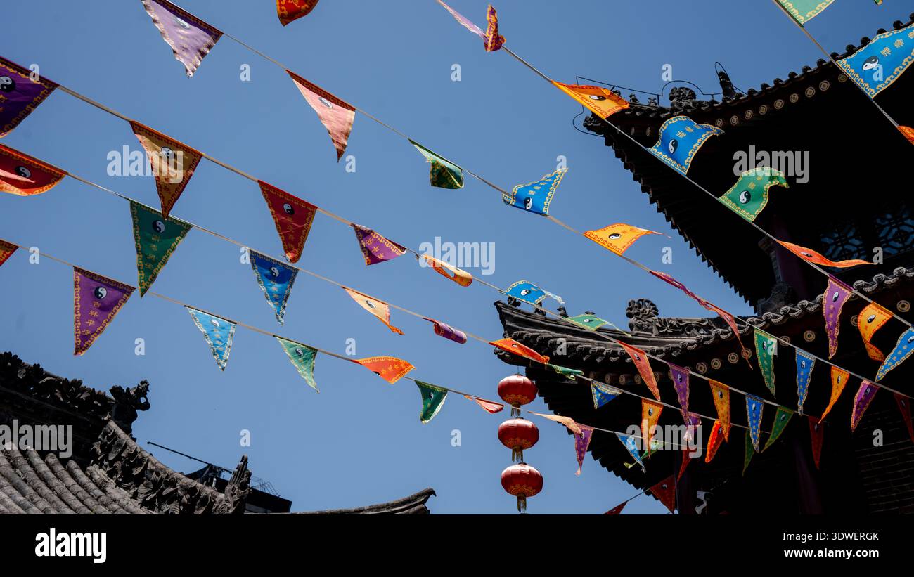 Drapeaux triangulaires colorés et architecture traditionnelle au Temple du Dieu à Xian, en Chine, capturent l'essence d'un patrimoine culturel dynamique et d'un Banque D'Images