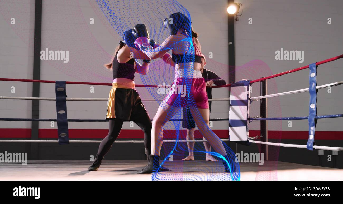 Sparring deux boxers échangeant des coups dans la bague de gymnastique, portant des gants, des chapeaux, des shorts foncés et un haut rose Banque D'Images
