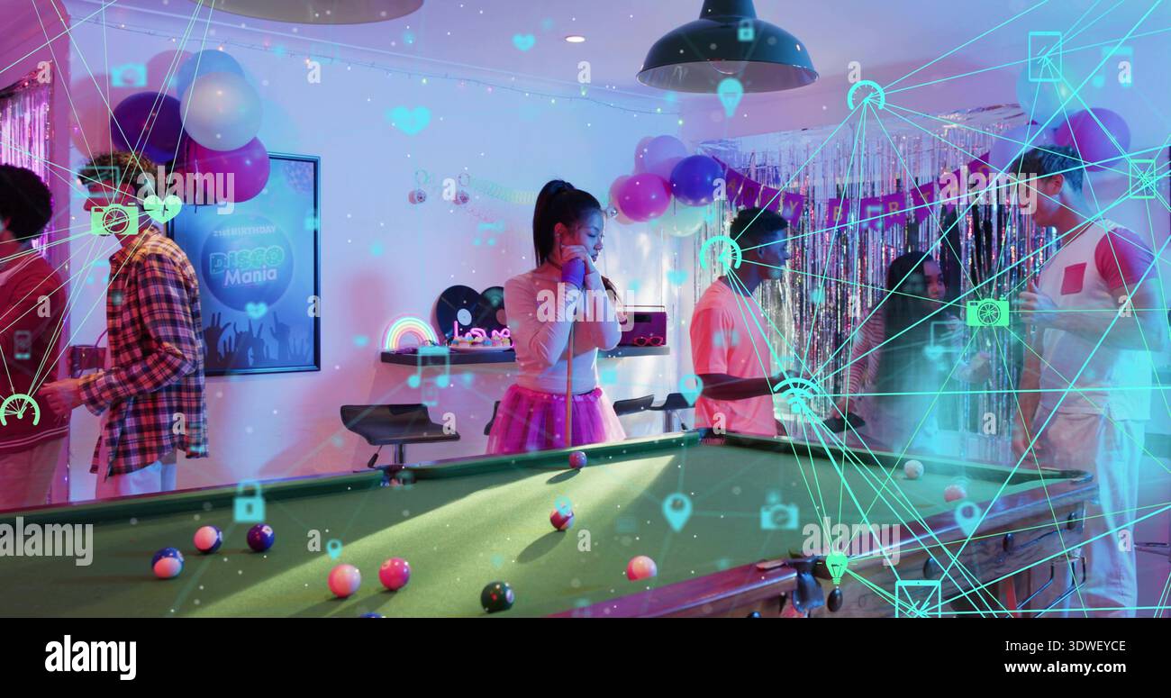 Jouer les invités dans des tenues festives autour d'une table de billard en feutre vert dans la salle de fête, avec des repères, recouvrement AR Banque D'Images