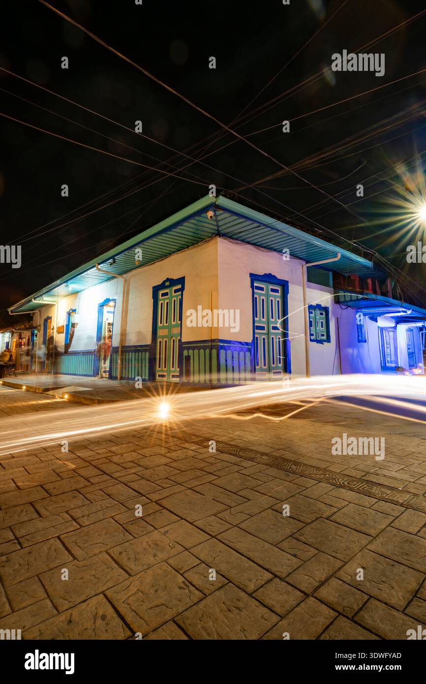 Scène de rue vibrante capturée la nuit dans le Salento, Colombie, mettant en valeur l'architecture coloniale colorée sous un éclairage dynamique, reflétant le culte Banque D'Images