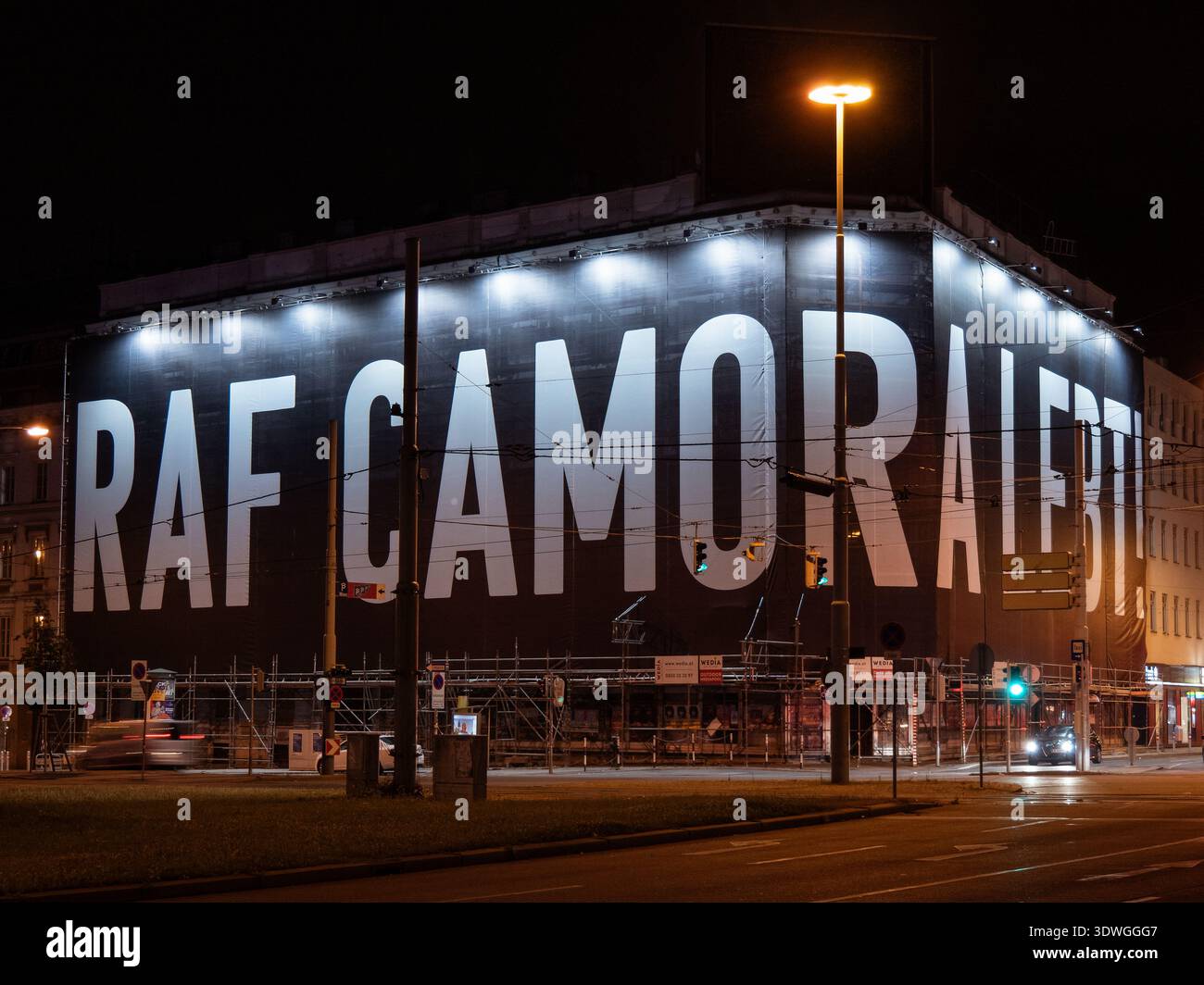 Publicité géante RAF Camora sur échafaudage de construction dans la nuit de Vienne, panneau d'affichage illuminé sur le chantier, scène de rue urbaine. Banque D'Images