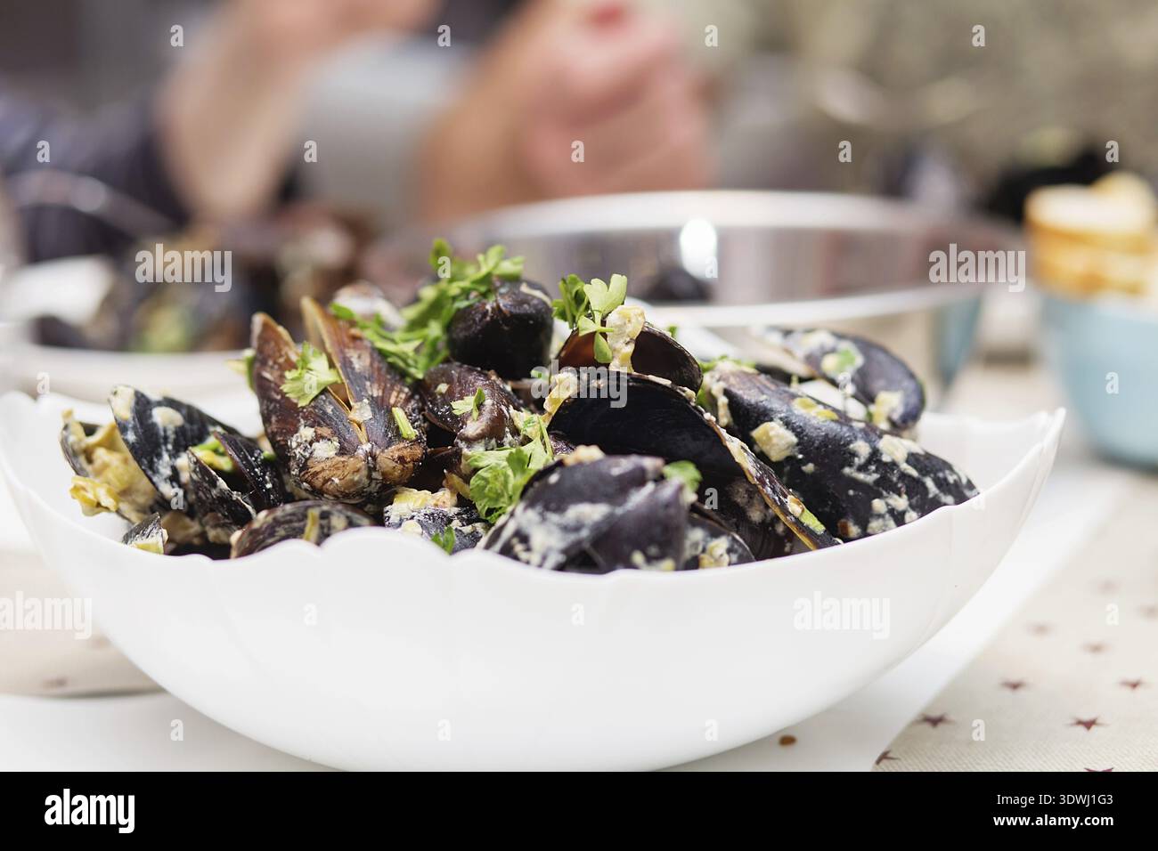 Moules cuites à la vapeur dans une sauce au fromage. Moules en coquilles dans le bol avec du vin blanc sur la table Banque D'Images