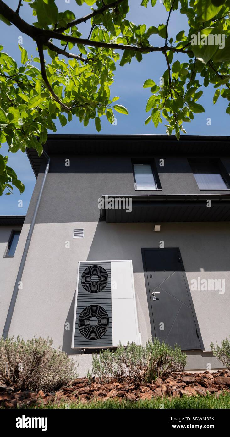Le mur d'un chalet moderne accueille l'unité extérieure d'une pompe à chaleur. Banque D'Images