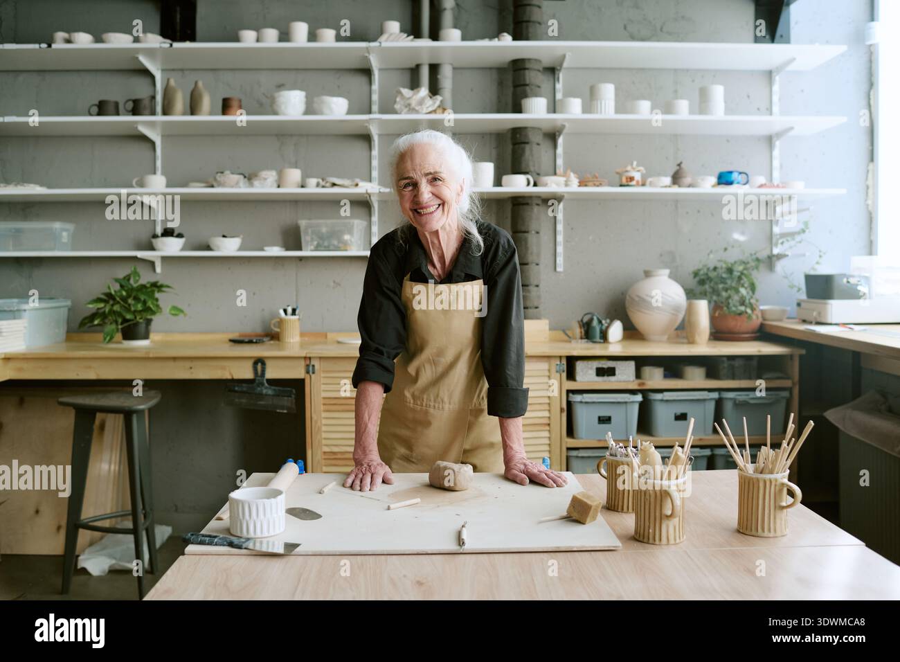 Portrait de femme senior souriante tout en travaillant dans Pottery Studio Banque D'Images