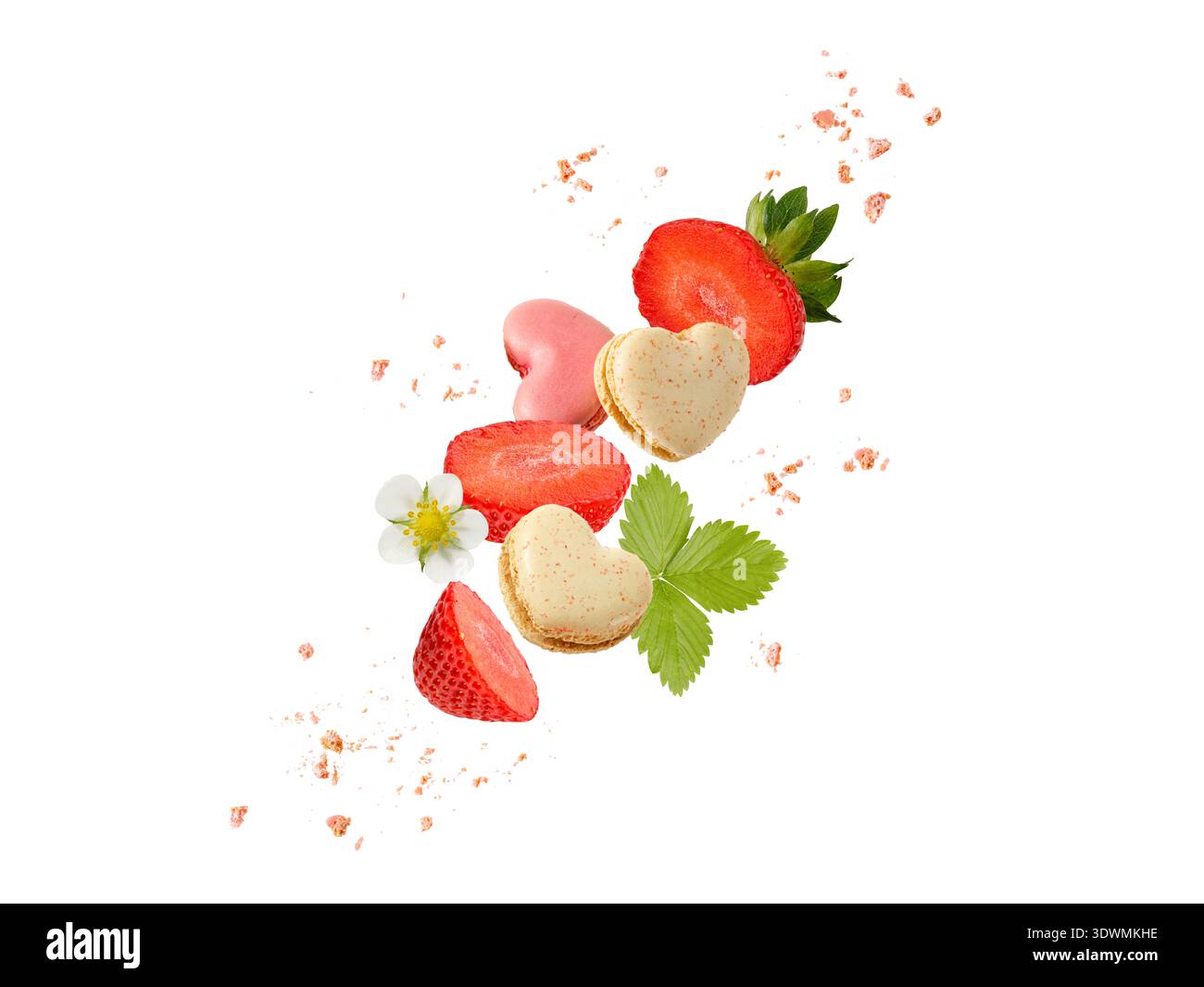 Macarons doux macarons en forme de coeur, tranches de fraises et miettes volant isolé sur fond blanc. Biscuits français à la vanille et à la fraise Banque D'Images
