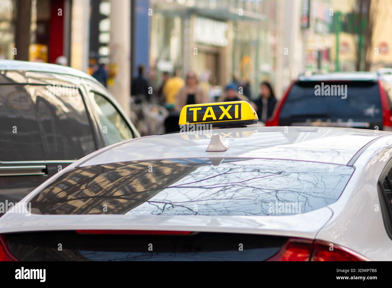 Voiture de taxi avec panneau jaune sur la rue de la ville autrichienne parmi les piétons. Banque D'Images