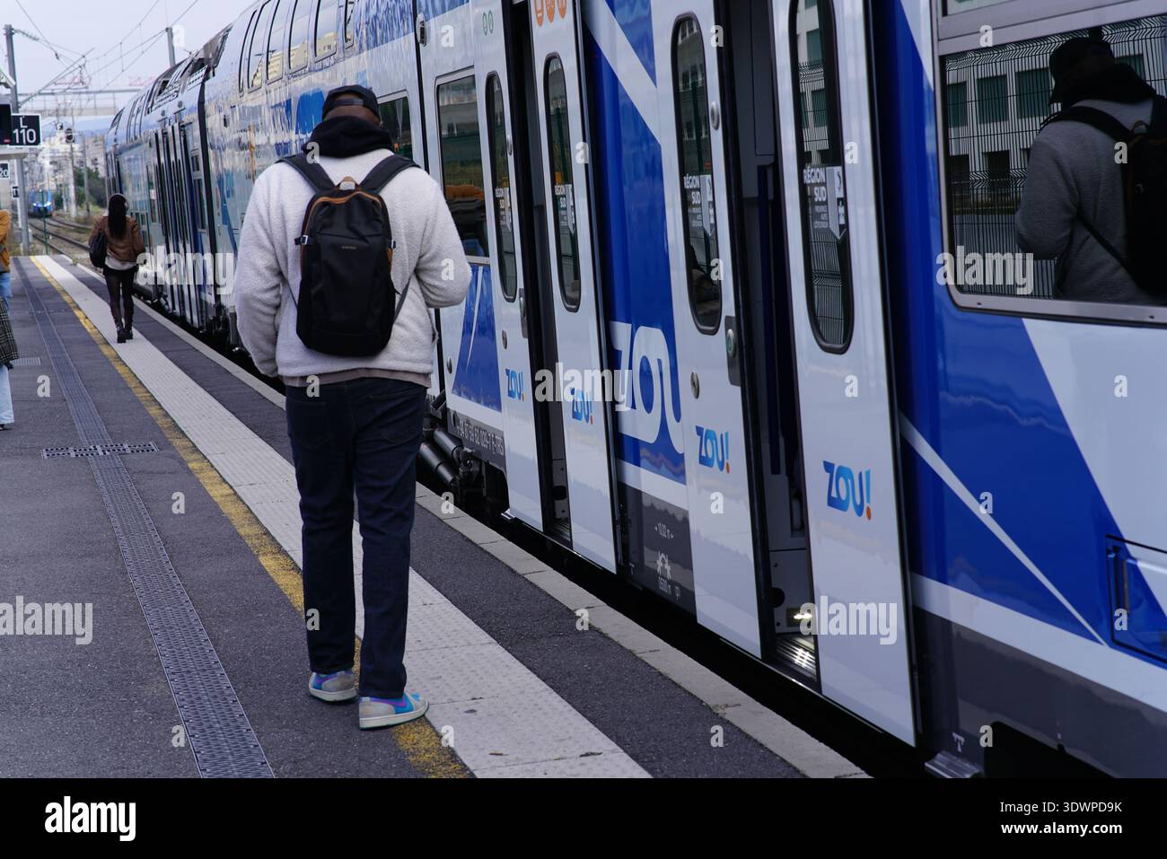 Passager en attente pour monter à bord DU ZOU ! Train régional au quai Gare de Nice-ville, livrée bleue et portes ouvertes, gare Nice French Riviera.Nice, France Banque D'Images
