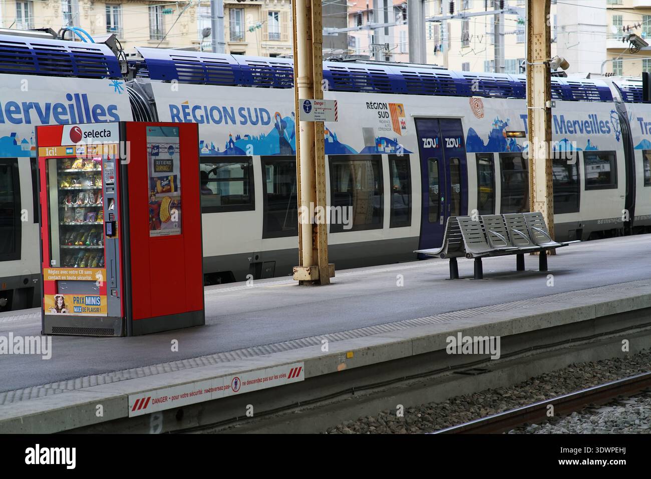 Distributeur automatique Red Selecta sur le quai historique à côté du train bleu Zou « merveilles du Sud » sous des colonnes dorées à la gare de Nice ville. Banque D'Images