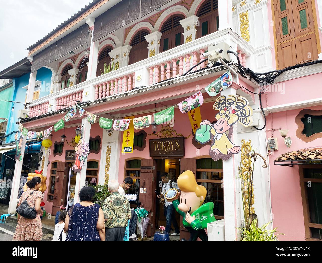 Phuket, Thaïlande - 28 octobre 2025 : bâtiment de style colonial dans la vieille ville de Phuket avec des éléments décoratifs et des visiteurs s'engageant avec le vif magasin Banque D'Images