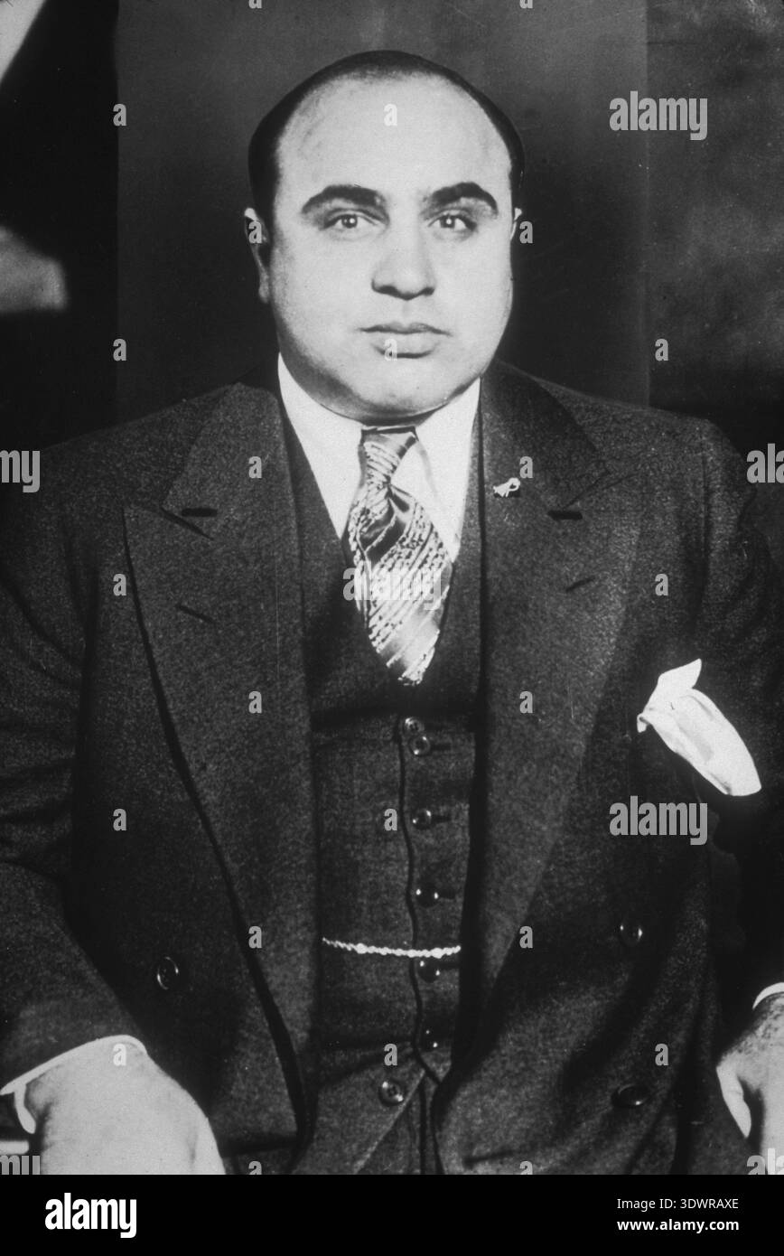 Portrait vintage en studio noir et blanc d'Al Capone (v. 1935), le célèbre gangster américain. La photographie sérieuse et intense capture le personnage tristement célèbre de l'ère de la Prohibition, reflétant sa puissante réputation dans le crime organisé. Banque D'Images