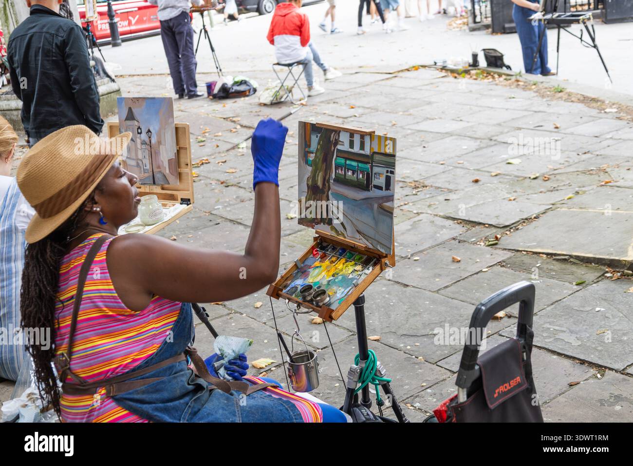 Femme peintre travaillant sur une toile en public. Londres, Royaume-Uni, 10 août 2024 Banque D'Images