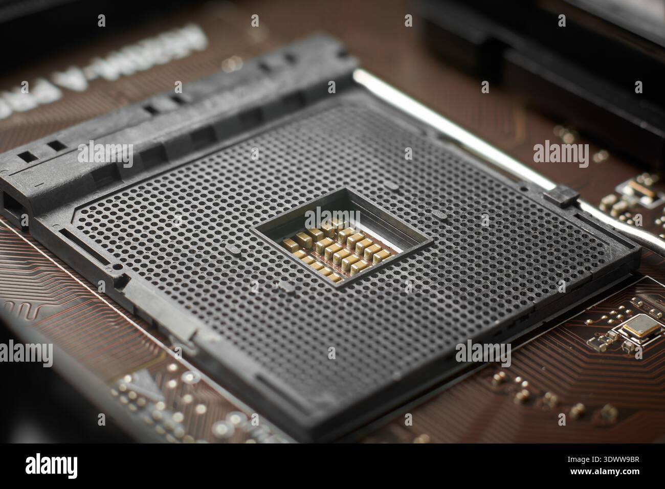 support cpu en plastique noir vide sur la surface de la carte mère, petits trous de contact et composants électroniques centraux, vue de dessus gros plan avec soft focus Banque D'Images