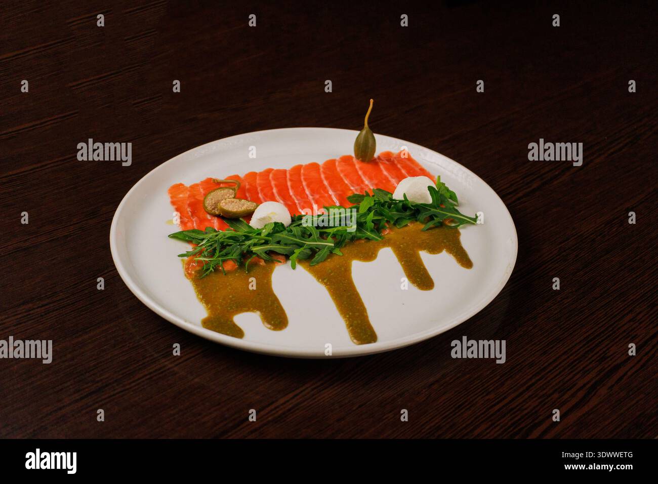 Une assiette avec des tranches de poisson rouge, du pain et des légumes verts Banque D'Images