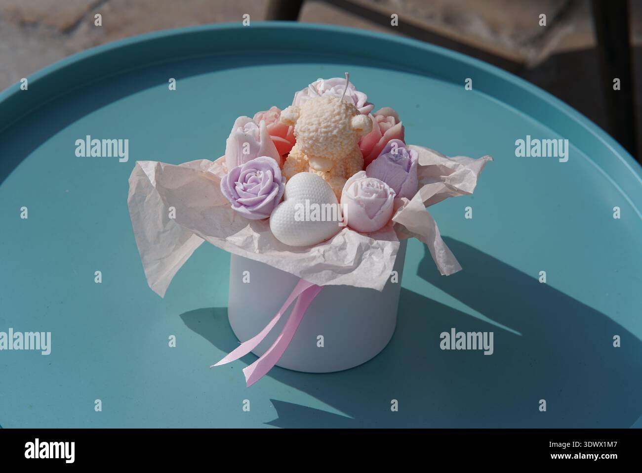 Bouquet de fleurs de savon fait à la main pastel dans une boîte cadeau blanche avec ruban rose sur plateau turquoise .Menton, France Banque D'Images