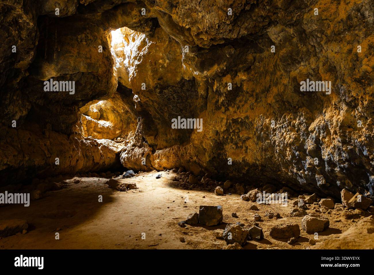 La lumière du soleil pénètre par les ouvertures du plafond éclairant l'intérieur d'une grotte de lave dans le désert de Mojave Banque D'Images