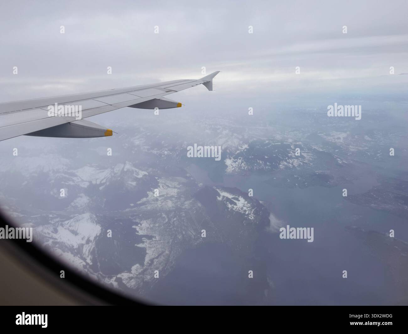 Vue d'une fenêtre d'avion montrant une aile au premier plan. La vue de l'avion était sur sa route de Zurich à Rome. Banque D'Images