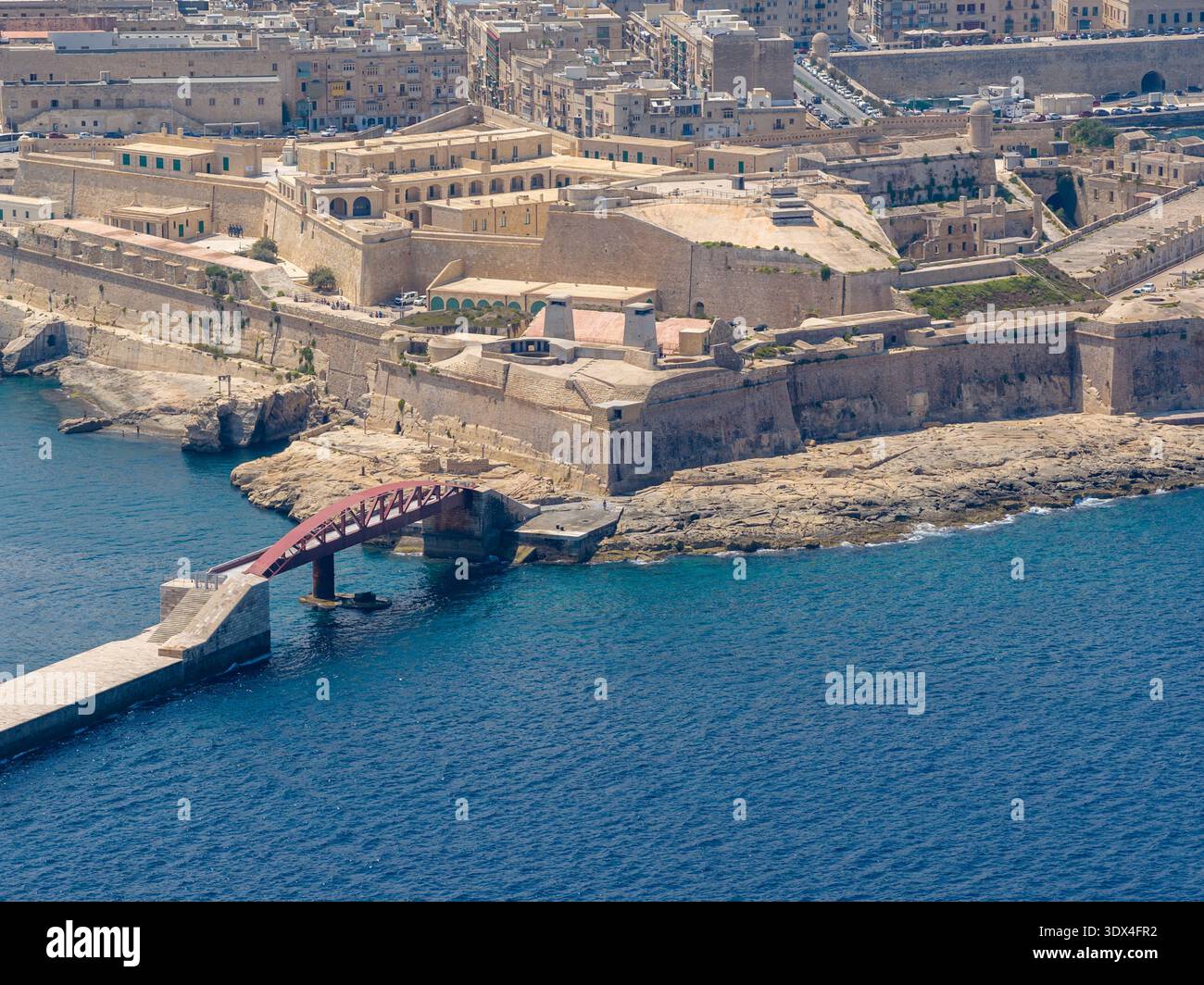Vue de, Elmo Bridge enjambant l'eau près de Fort Elmo à la Valette, Malte, avec des fortifications en pierre et la mer bleue par temps clair. Banque D'Images