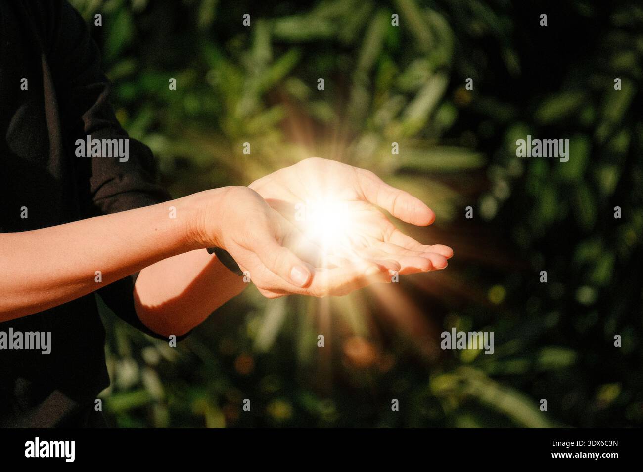 Femme d'âge moyen tenant la lumière brillante d'or dans ses mains comme donner pour gagner symbole de l'autonomisation des femmes et le partage Banque D'Images