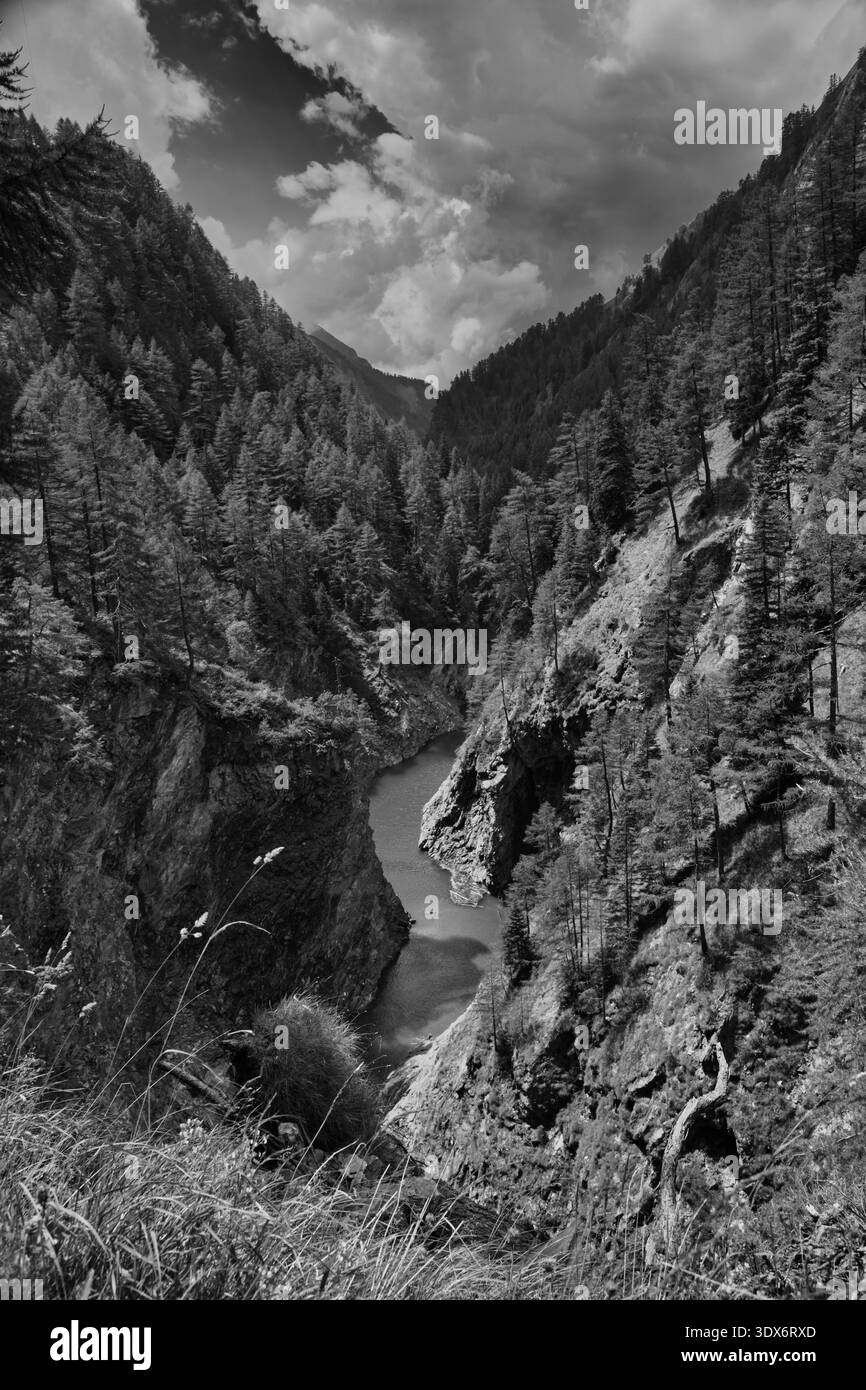Vue imprenable sur Un canyon à Luzzone, en Suisse, entouré de forêts denses et d'un ciel spectaculaire. Banque D'Images