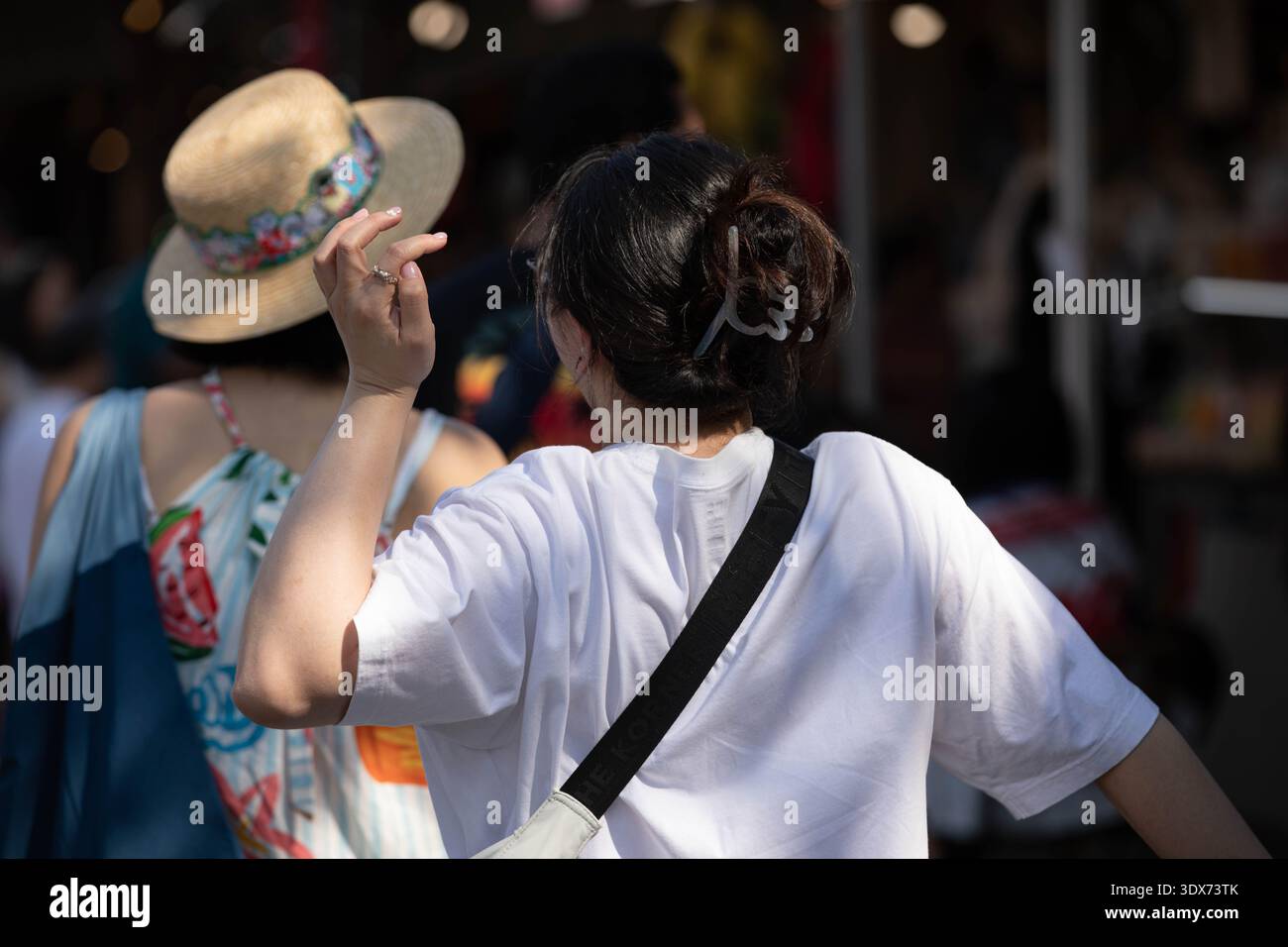Femme avec les cheveux noirs marchant dans le marché, style de vie du marché du week-end thaïlandais, voyageur explorant le marché en plein air, vue arrière, au marché de Chatuchak. Banque D'Images