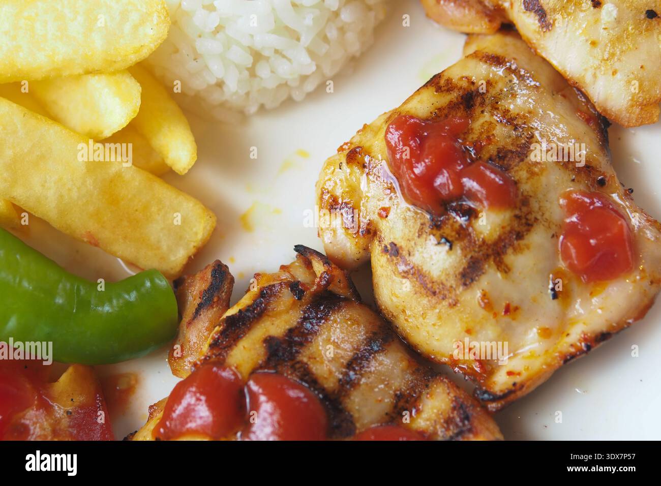 Poulet grillé avec riz et frites servi sur une assiette Banque D'Images