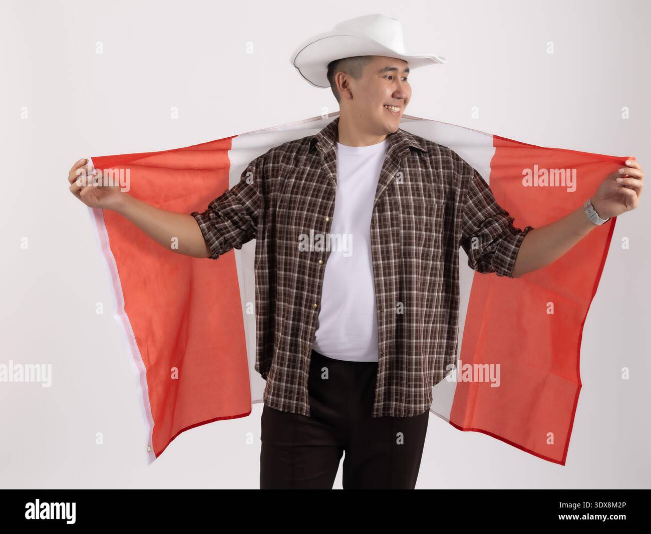 Homme en chapeau de cow-boy tenant le drapeau du Canada derrière son dos Banque D'Images
