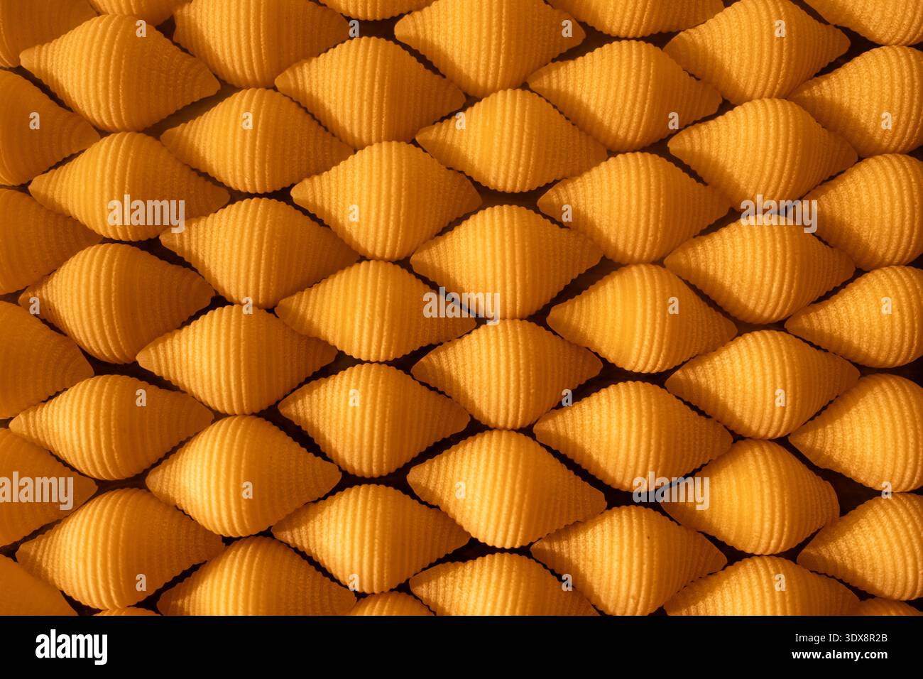 Texture abstraite de cônes métalliques dorés dans un motif répétitif Banque D'Images