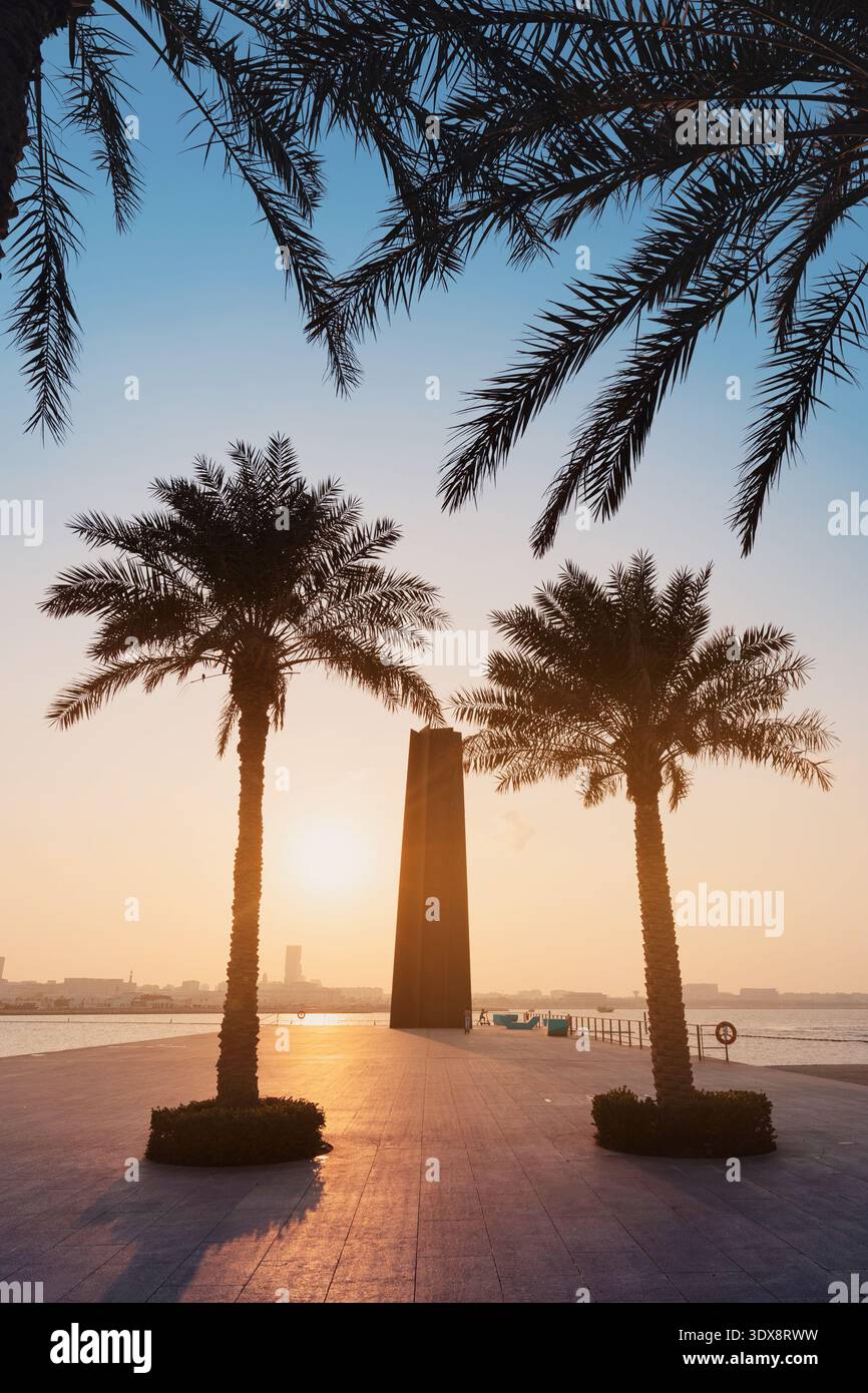 29 novembre 2025, Doha, Qatar : 7 sculpture de Richard Serra debout près de la promenade du front de mer avec des palmiers et un ciel de coucher de soleil vibrant Banque D'Images