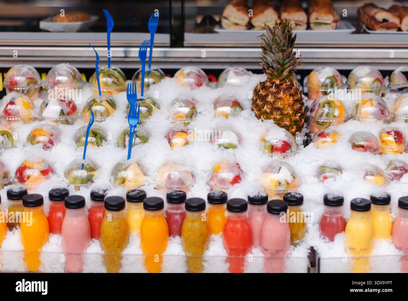 Coupes de fruits et jus de fruits exposés sur glace à un étal du marché de Barcelone Banque D'Images