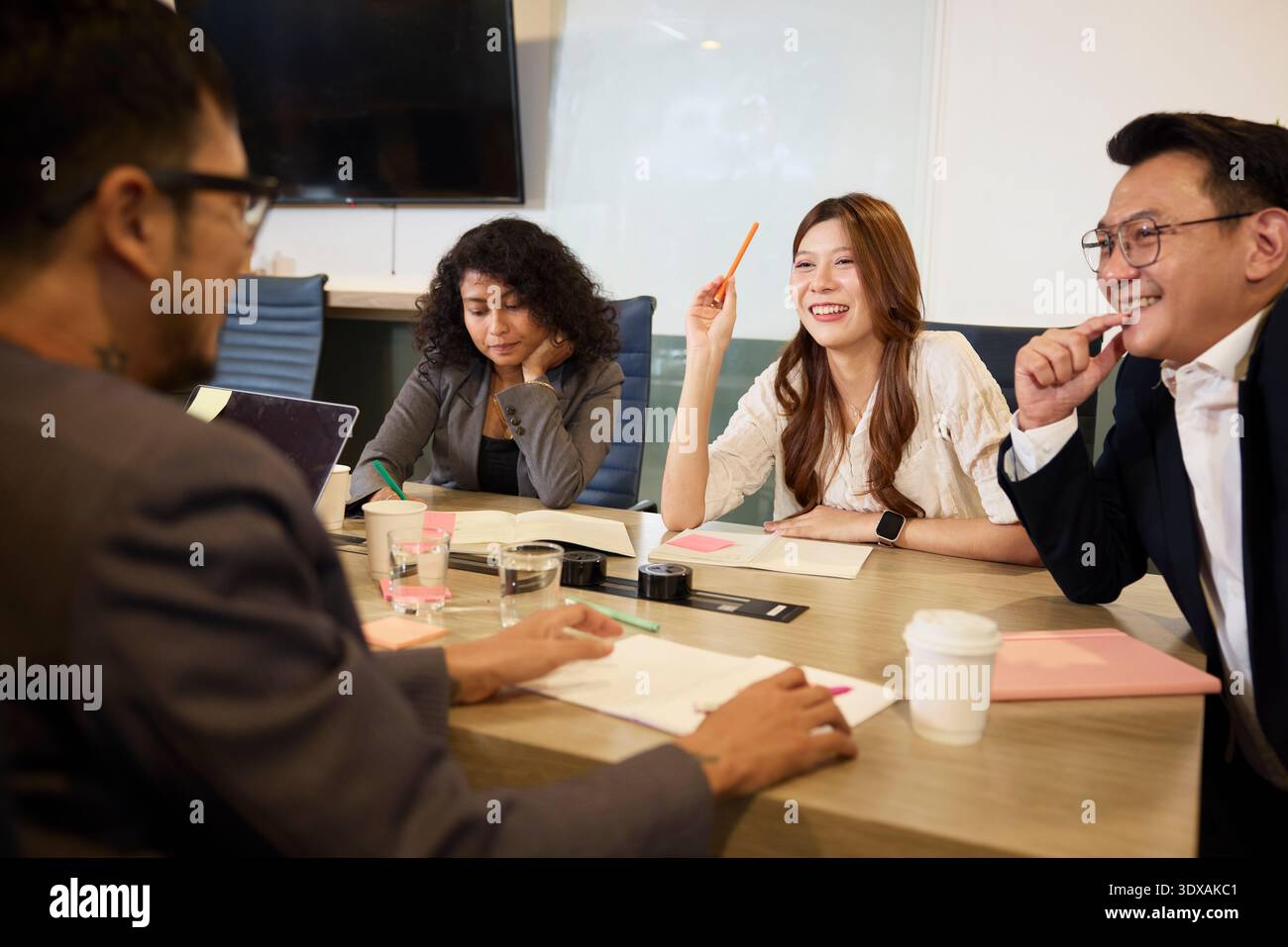 Entrepreneurs heureux assis autour de la table dans la salle de réunion au bureau Banque D'Images