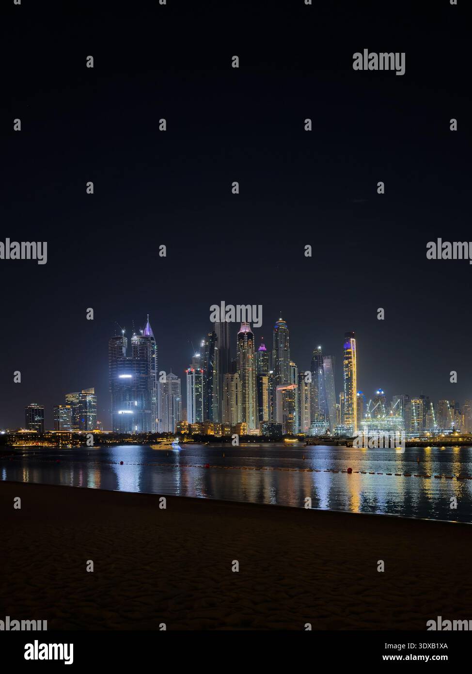 Skyline verticale des gratte-ciel de Dubaï la nuit, skyline illuminée avec des reflets magiques sur le front de mer de Marina. Banque D'Images