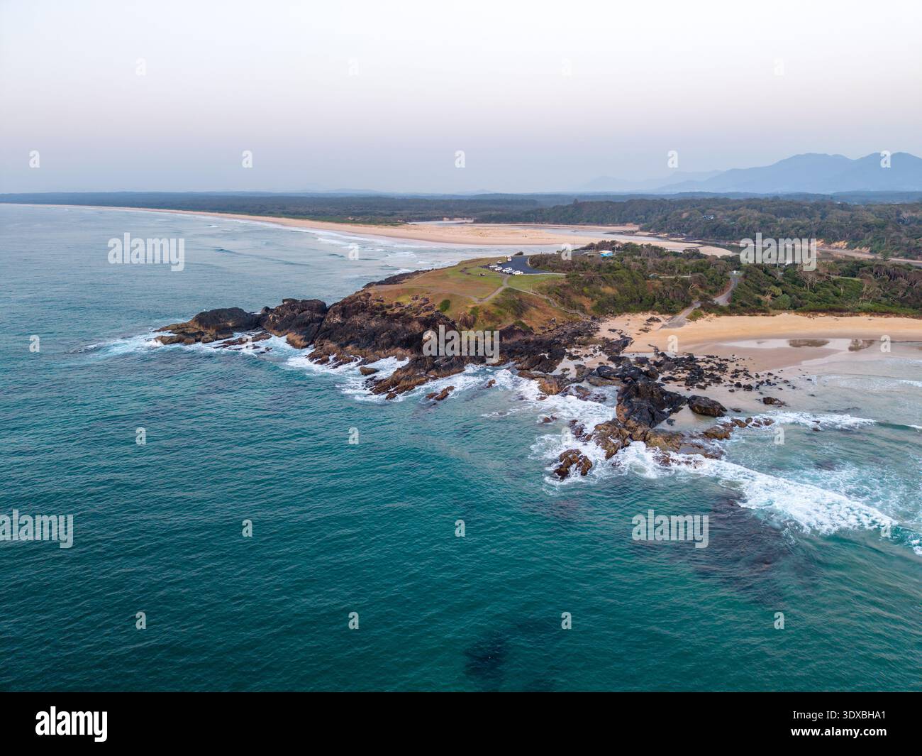 Vue aérienne de l'endroit où le promontoire rocheux rencontre l'océan turquoise, contrastant avec la plage de sable et la végétation dense, Sawtell, Nouvelle-Galles du Sud, A Banque D'Images
