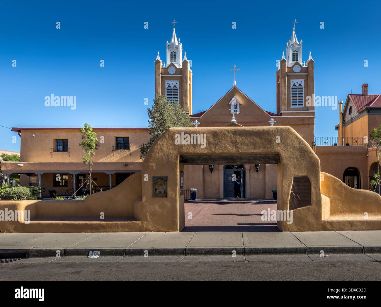 Winslow, États-Unis - 08 mai 2023 : vue de l'église historique la Purisima Concepcion, encadrée par une arche rustique en adobe, sous un ciel bleu clair. Banque D'Images