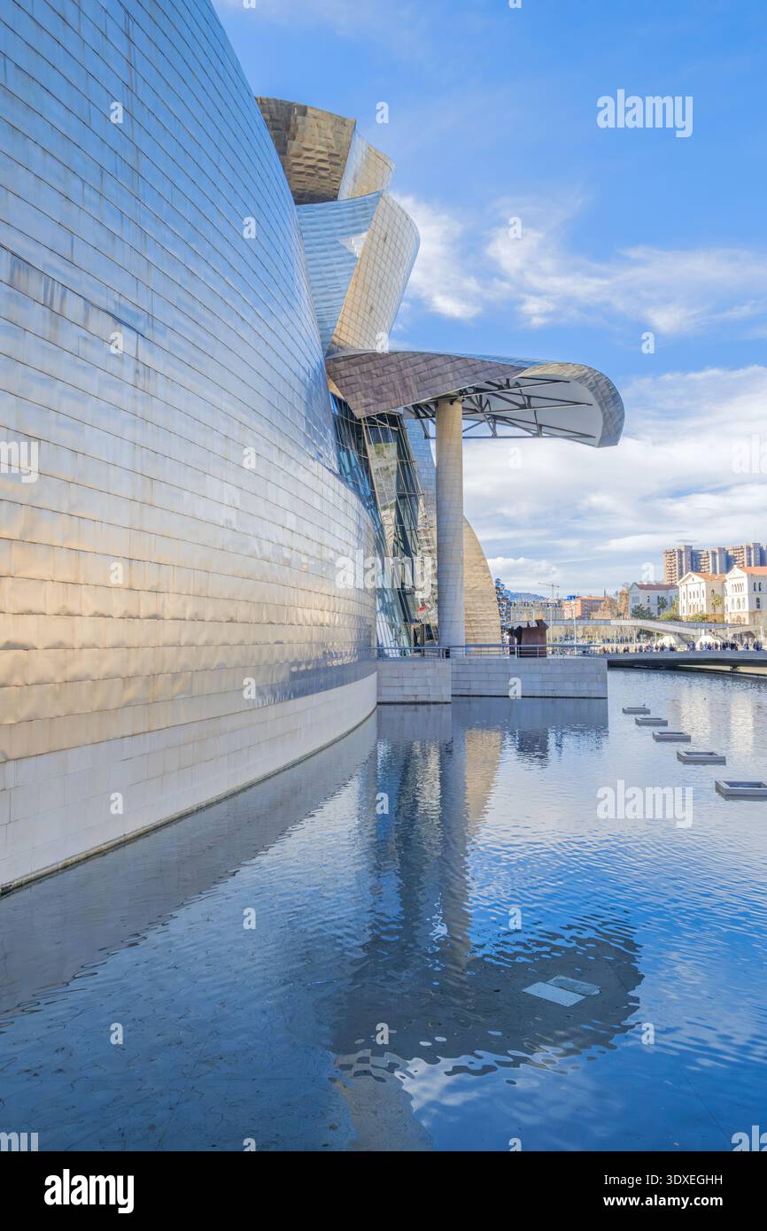 Musée Guggenheim Bilbao, vue détaillée des panneaux courbés en titane et de l'étang réfléchissant, Espagne Banque D'Images
