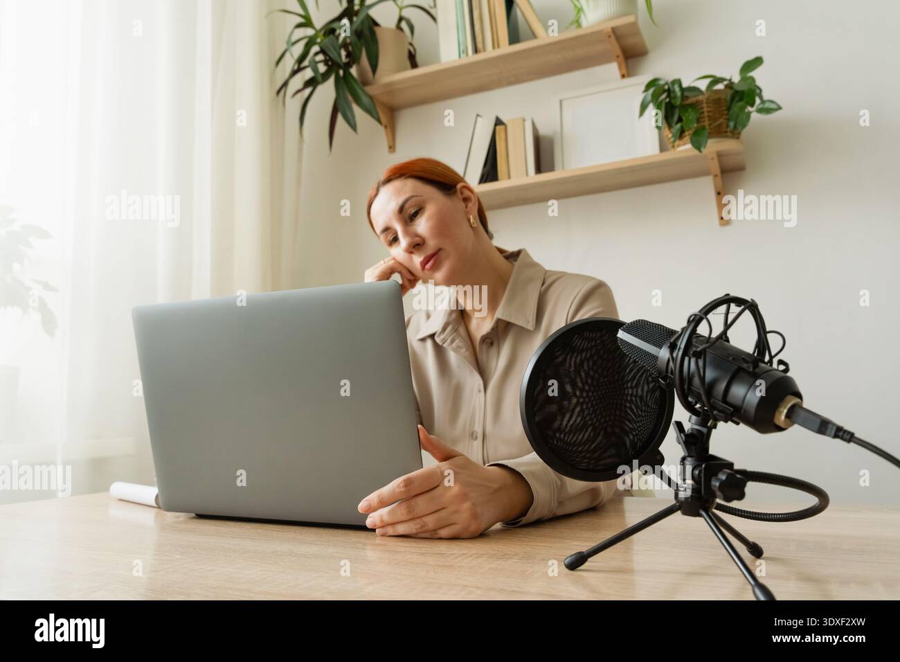 Femme enregistrant un podcast au home studio. Un blogueur psychologue populaire sur les réseaux sociaux tient une réunion vidéo sur sa chaîne Banque D'Images