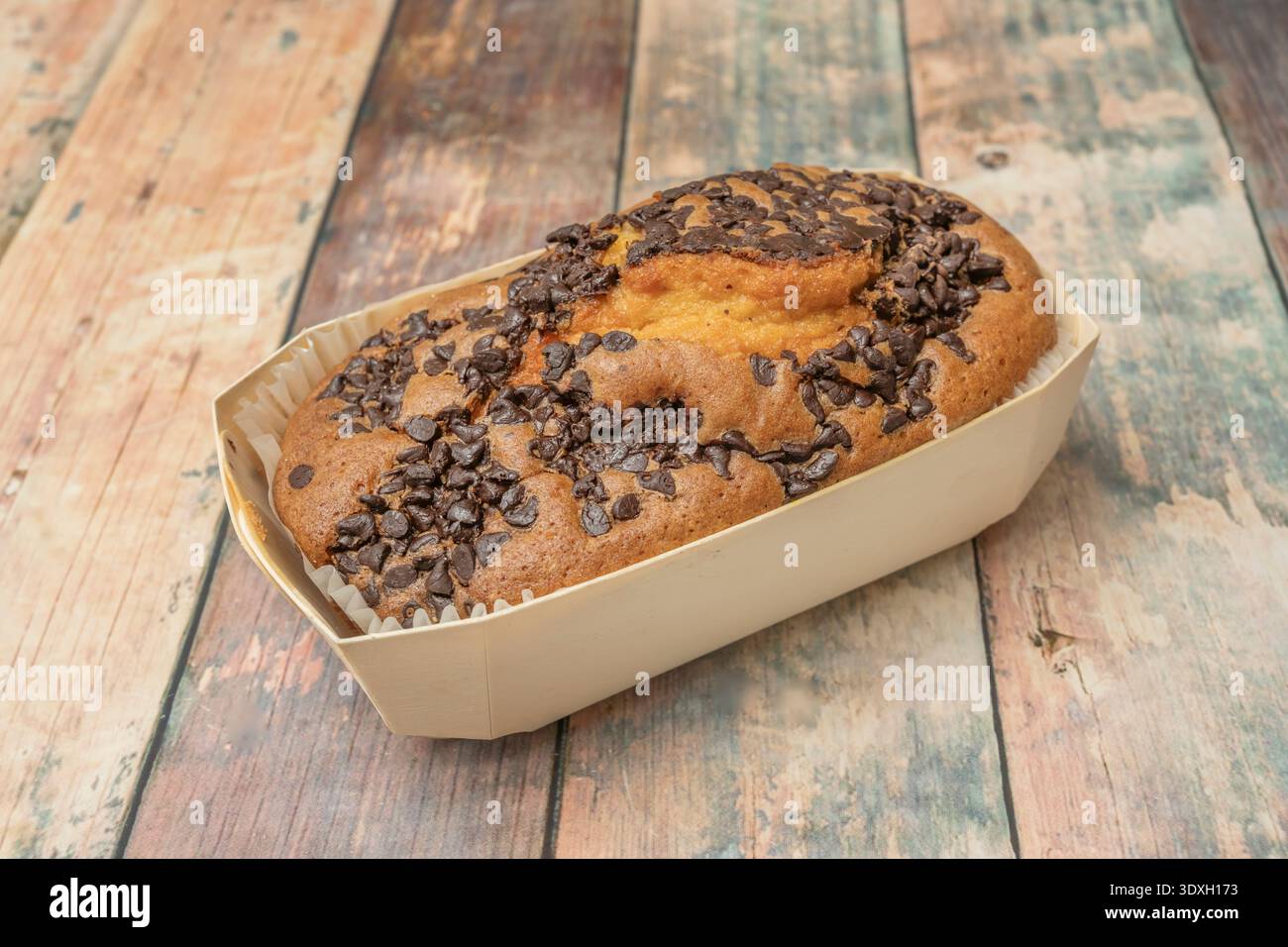 un gâteau éponge au chocolat rempli d'une crème de chocolat au lait lisse et recouvert d'une ganache miroir rouge rubis profonde qui reflète la lumière spectaculaire Banque D'Images