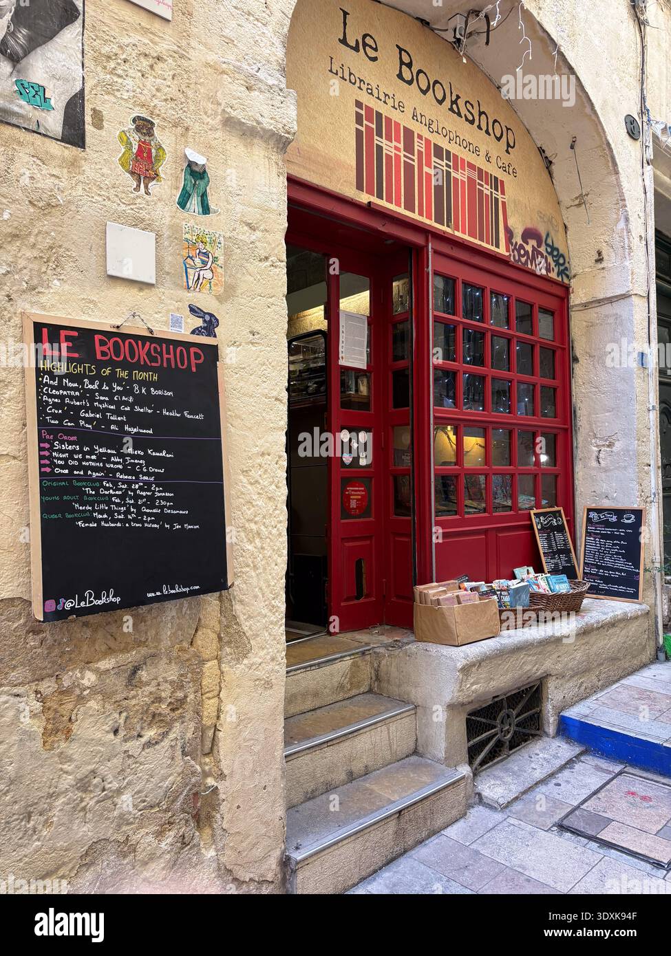 Le Bookshop librairie anglophone & Café entrée à Montpellier, France. Façade de magasin de livres de langue anglaise avec porte rouge et tableau noir promotionnel m Banque D'Images