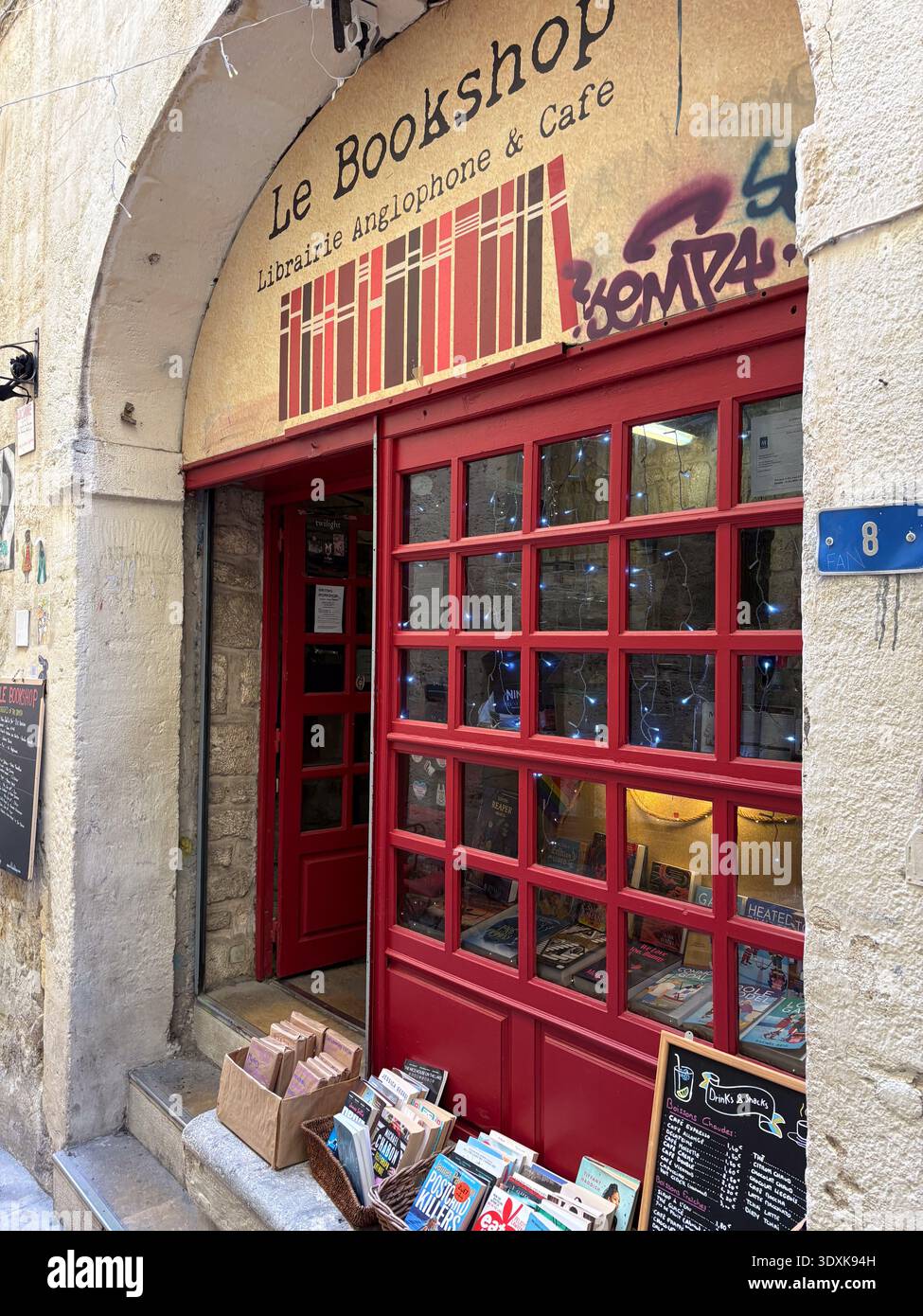 Le Bookshop, librairie anglophone & Cafe Storefront à Montpellier, France. Façade rouge vif, vitrines et livres à vendre à l'extérieur Banque D'Images