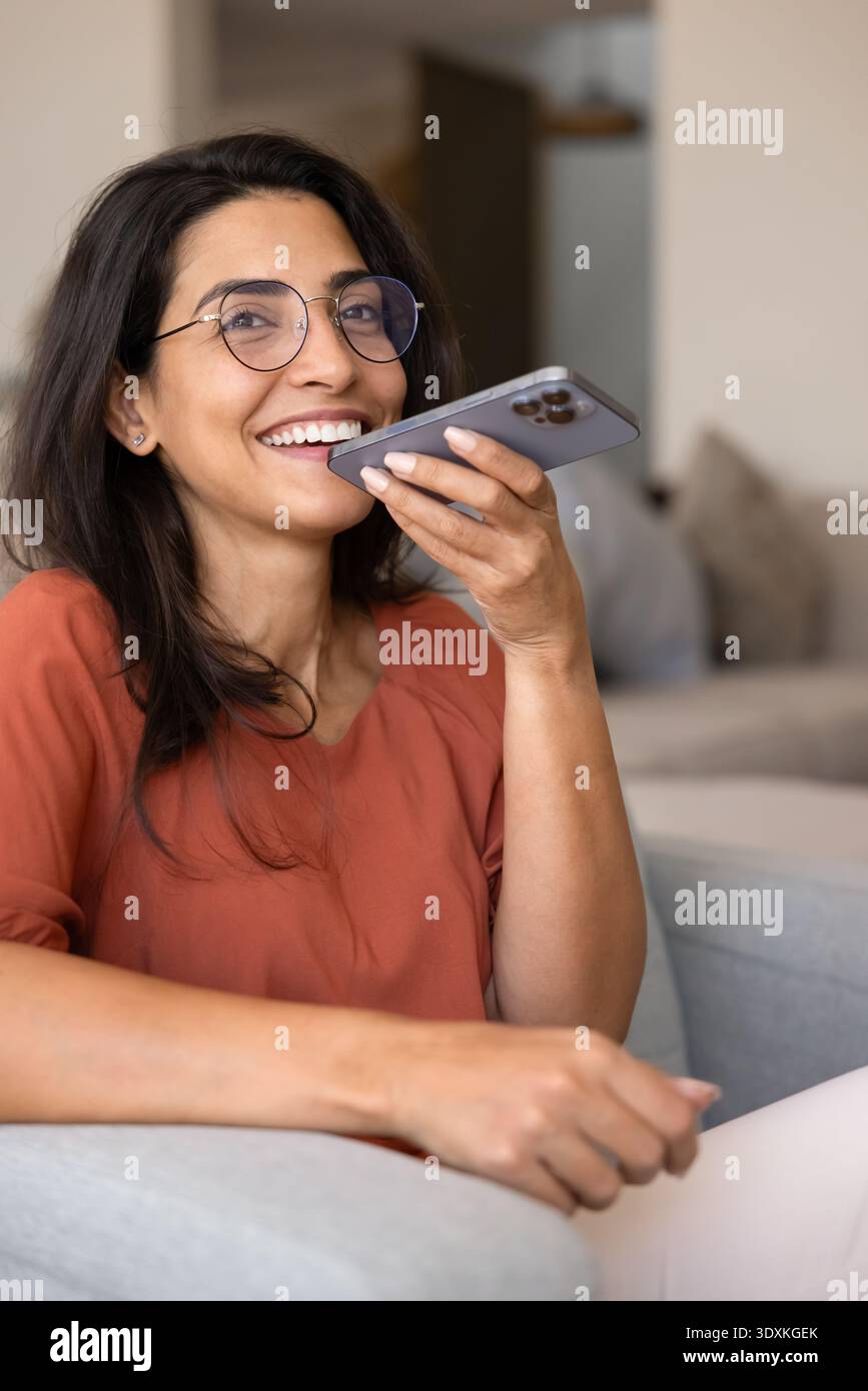 Femme heureuse utilisant l'assistant vocal sur smartphone Banque D'Images